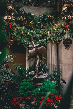 Statue surrounded by green garland